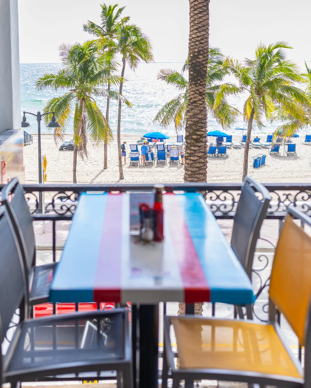 Colorful table seating at Lulu's Bait Shack overlooking Fort Lauderdale Beach and the Atlantic Ocean.