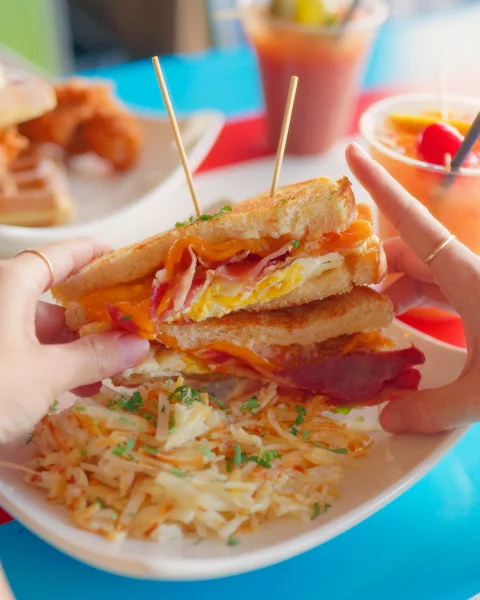 Ultimate Breakfast Sandwich with egg, bacon and melted cheese served with hashbrowns.