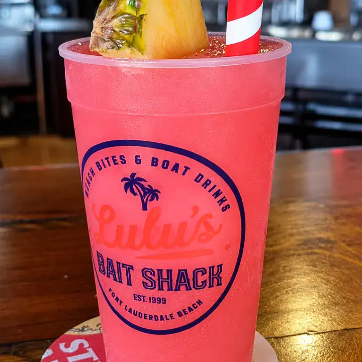 Pink frozen tropical drink served in a Lulu's souvenir cup.
