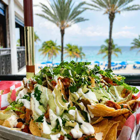 Loaded nachos served at Lulu's with Fort Lauderdale Beach in the background